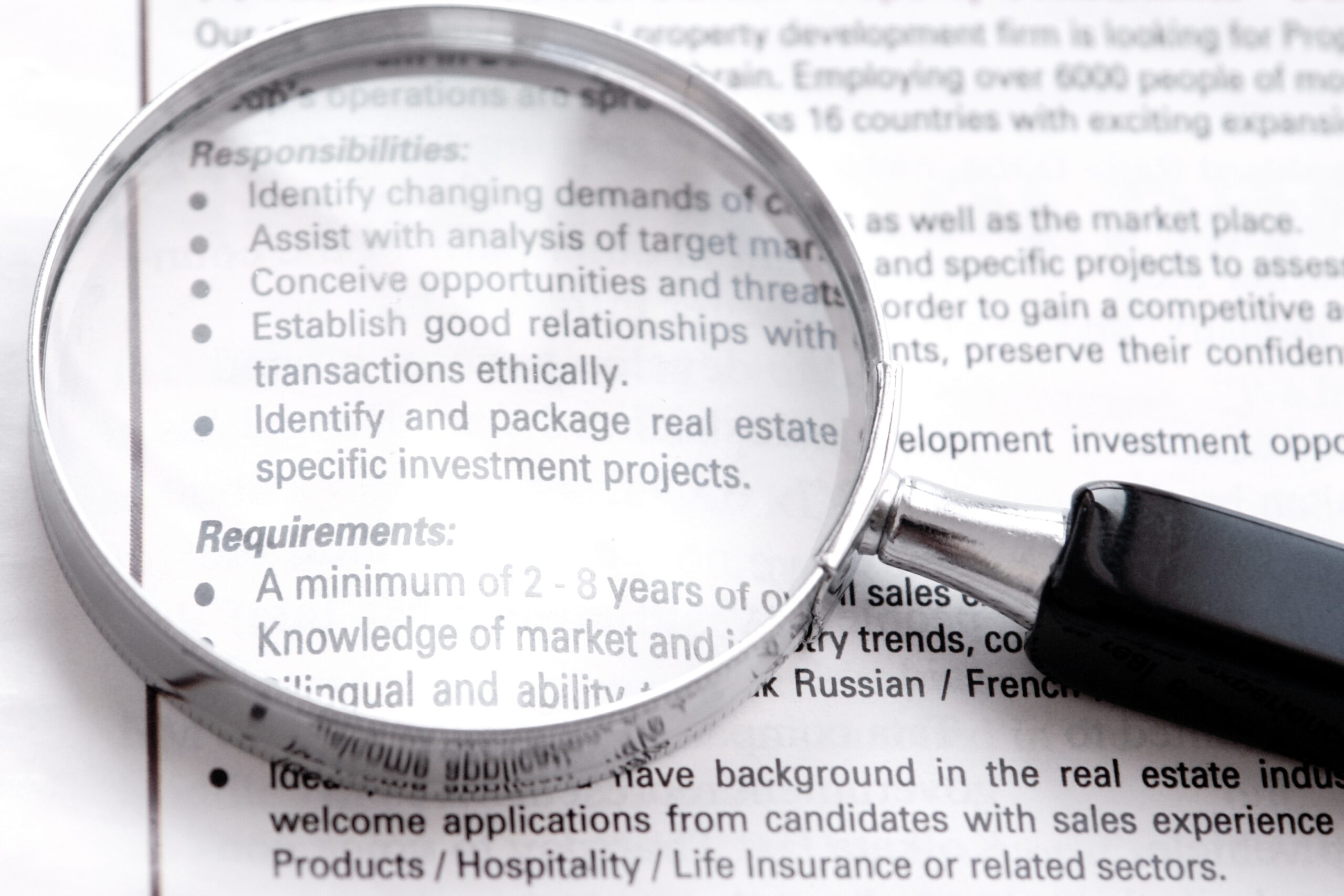 Searching a high level job on newspaper with a magnifier